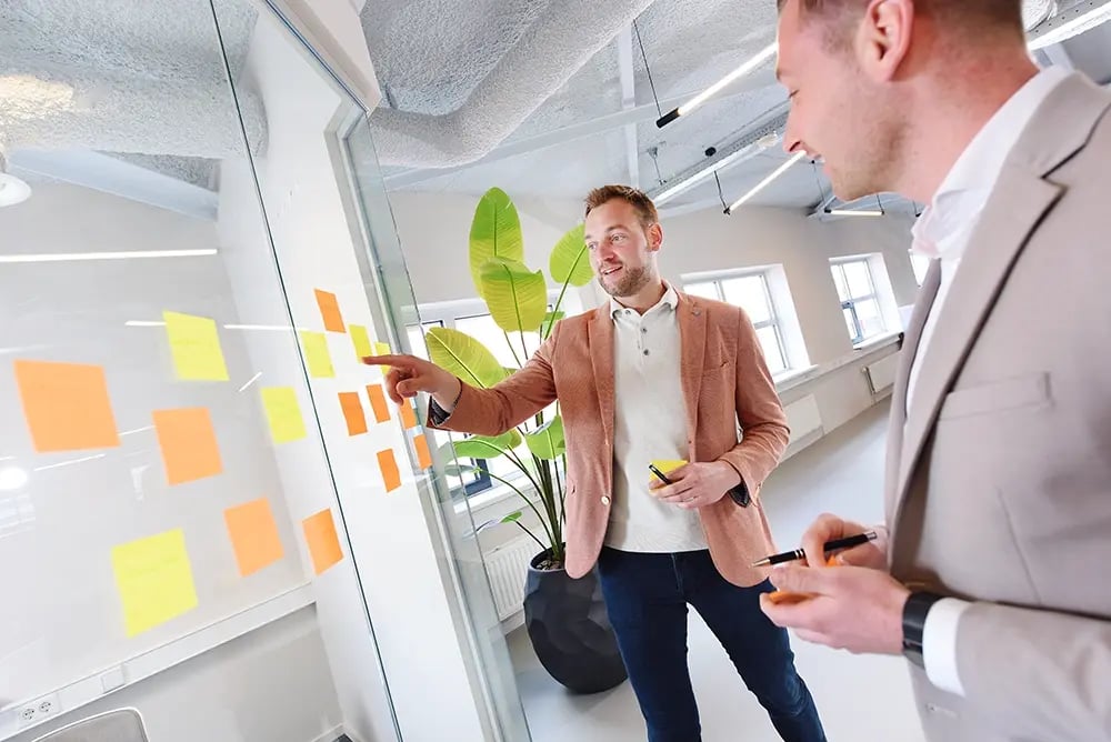 Michael en Dennis aan het overleggen bij de post-it muur