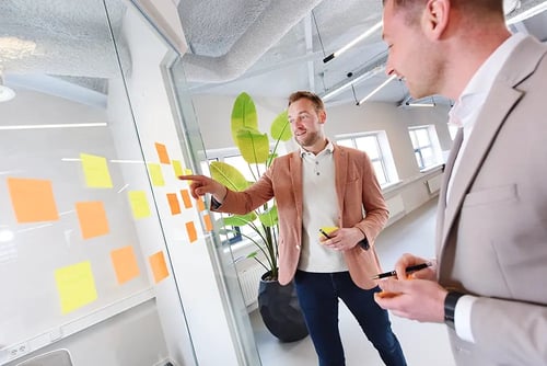 Michael en Dennis aan het overleggen bij de post-it muur
